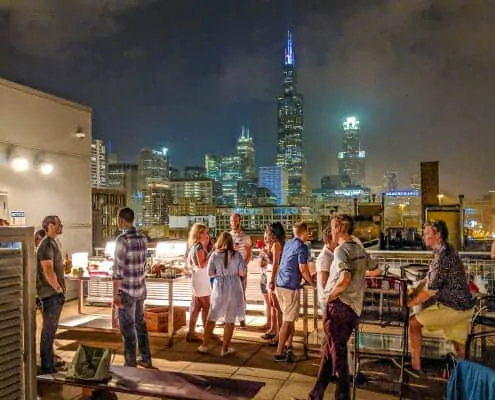 Night Roof Deck photo of a party with Chicago skyline in the back. 933 W. Van Buren, Chicago, IL 60607