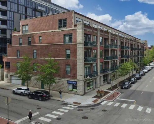 Exterior of Monroe Manor Condominiums, 841-849 W Monroe Street, Chicago IL 60607. A 5 story brick and stone condo building with terraces and balconies.